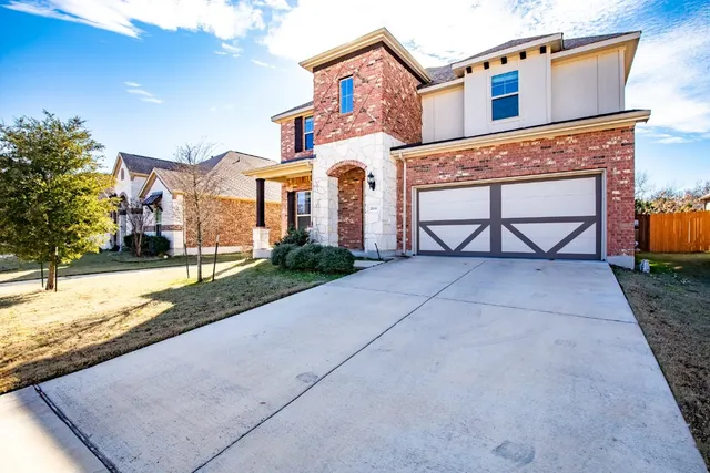 a front view of a house with a yard and garage