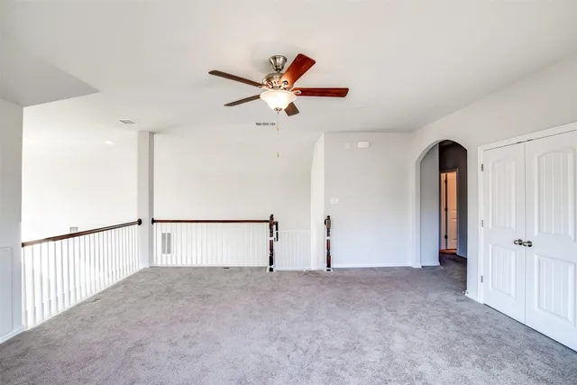 an empty room with fan and mirror