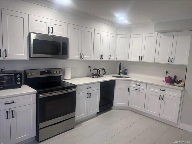 a kitchen with cabinets stainless steel appliances and sink