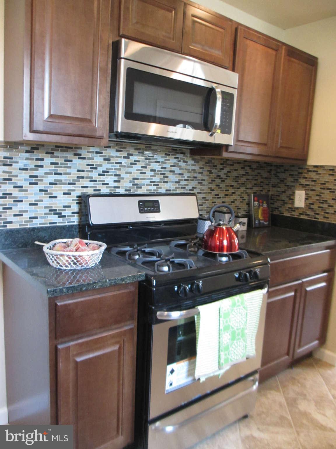 6600 Poplar Road Morningside, MD 20746 - Photo 9 of 13 a kitchen with stainless steel appliances granite countertop a sink stove and microwave