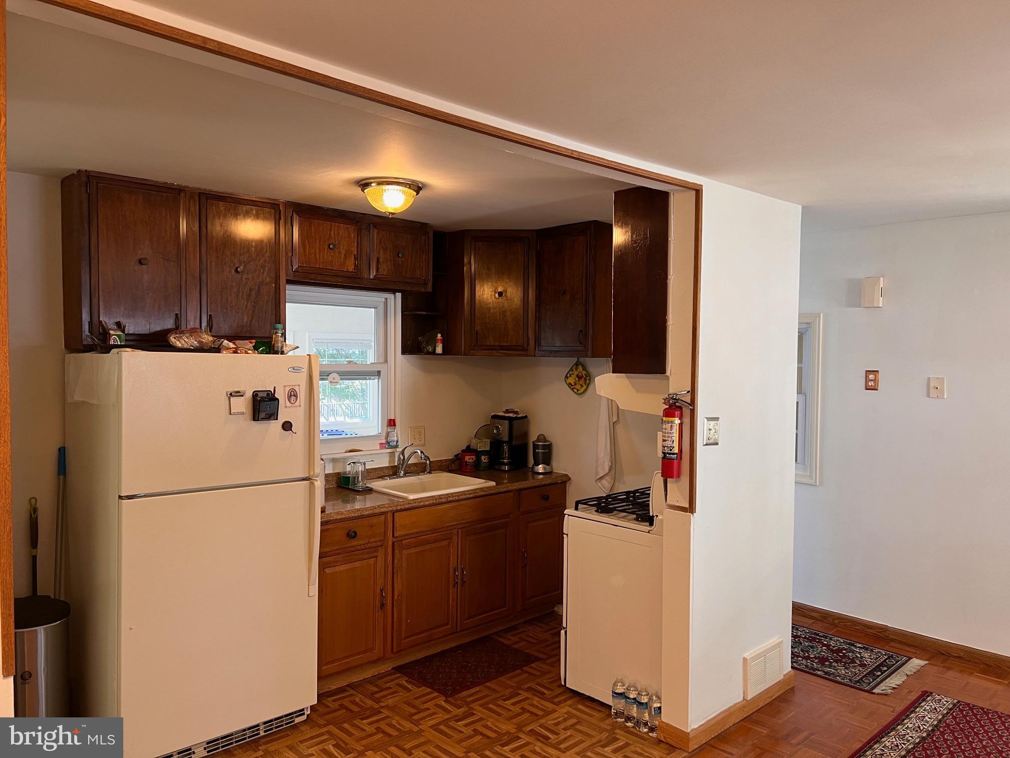 12205 Goodhill Road Silver Spring, MD 20902 - Photo 24 of 35 a kitchen with a refrigerator a stove top oven a sink and cabinets