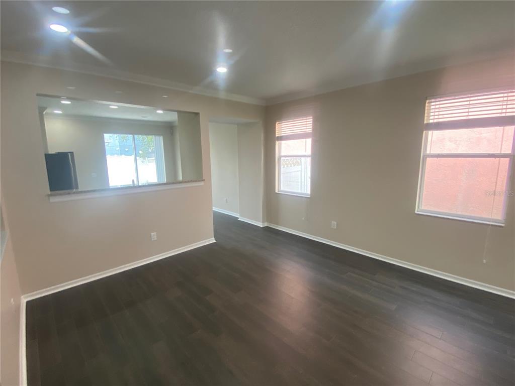 2409 Spring Hollow Loop Wesley Chapel, FL 33544 - Photo 5 of 47 an empty room with wooden floor and windows