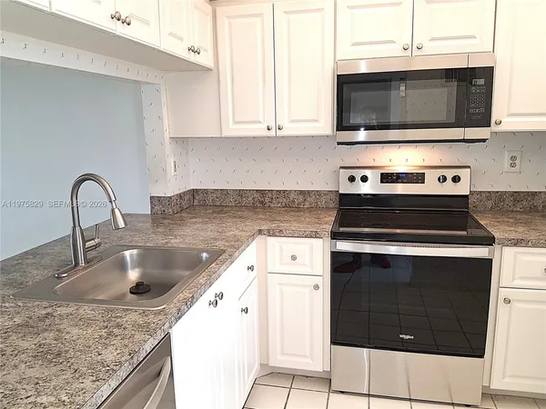 a kitchen with stainless steel appliances granite countertop a stove microwave and sink