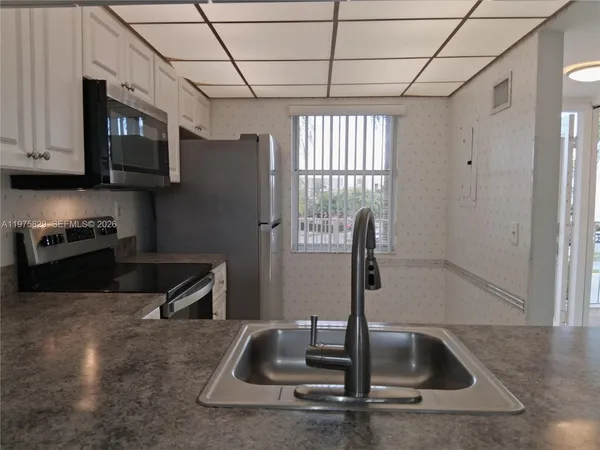a kitchen with granite countertop a sink and a window