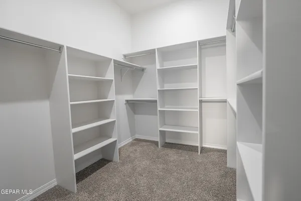 a view of walk in closet with empty racks