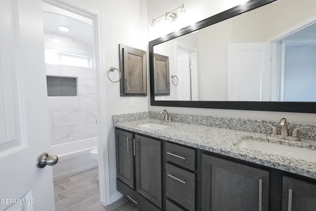 a bathroom with a granite countertop sink and a mirror
