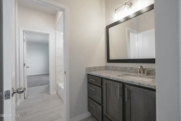 a bathroom with a granite countertop sink and a mirror