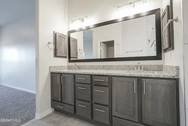 a bathroom with a granite countertop sink and a mirror
