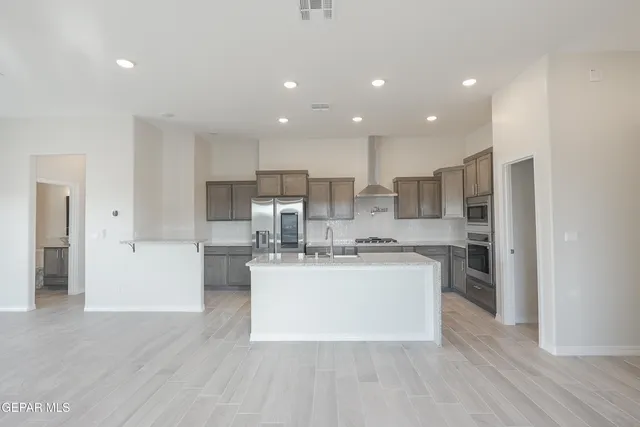a kitchen with stainless steel appliances a refrigerator and a stove top oven