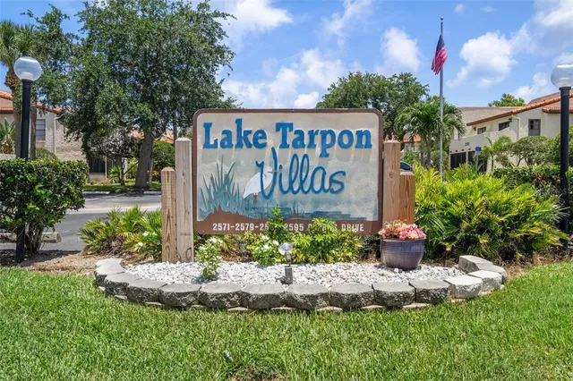 a view of a white house with a yard and palm trees