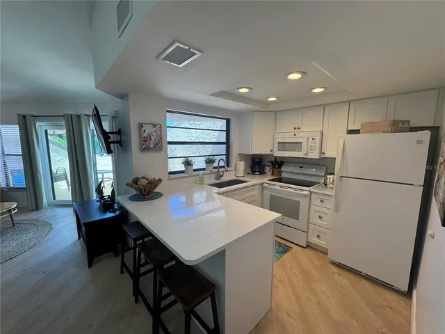 a kitchen with refrigerator cabinets dining table and chairs