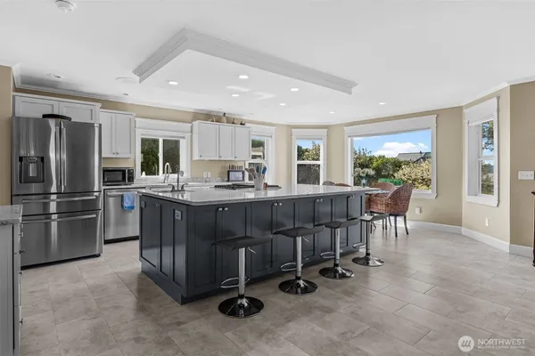 a kitchen with granite countertop a sink stove top oven and refrigerator