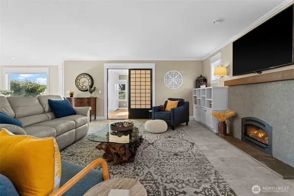 a living room with furniture a fireplace and a floor to ceiling window