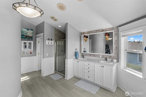 a spacious bathroom with a window double vanity and a mirror