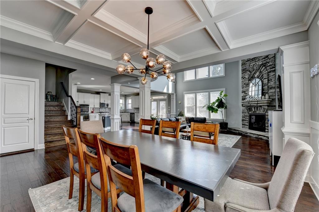 4071 Woodward Walk Lane Suwanee, GA 30024 - Photo 12 of 50 a dining room with wooden floor a chandelier a wooden table and chairs