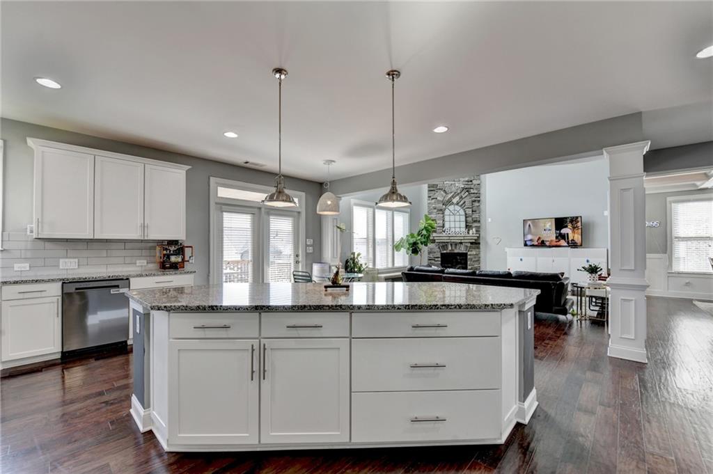 4071 Woodward Walk Lane Suwanee, GA 30024 - Photo 19 of 50 a kitchen with kitchen island granite countertop a sink a counter space appliances and cabinets