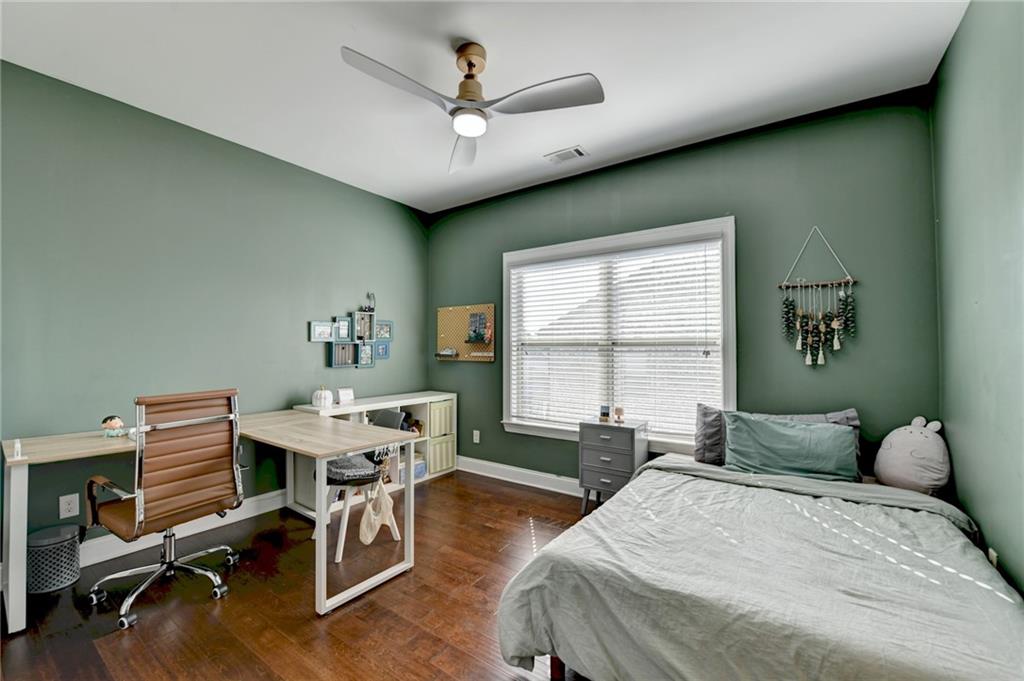 4071 Woodward Walk Lane Suwanee, GA 30024 - Photo 24 of 50 a bedroom with a bed and a desk
