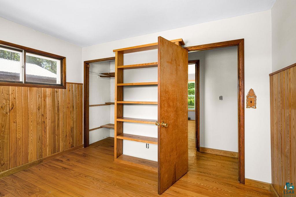 2592 Strandberg Road Barnum, MN 55707 - Photo 34 of 44 Room featuring wood-finish flooring, natural wood paneling, and a built-in shelving unit