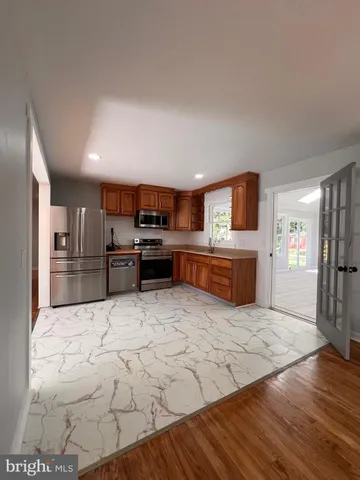 a large kitchen with cabinets and wooden floor