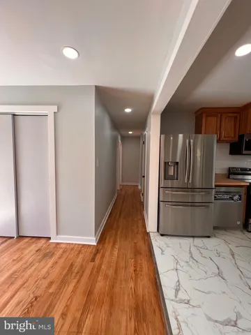 a view of kitchen with refrigerator and wooden floor