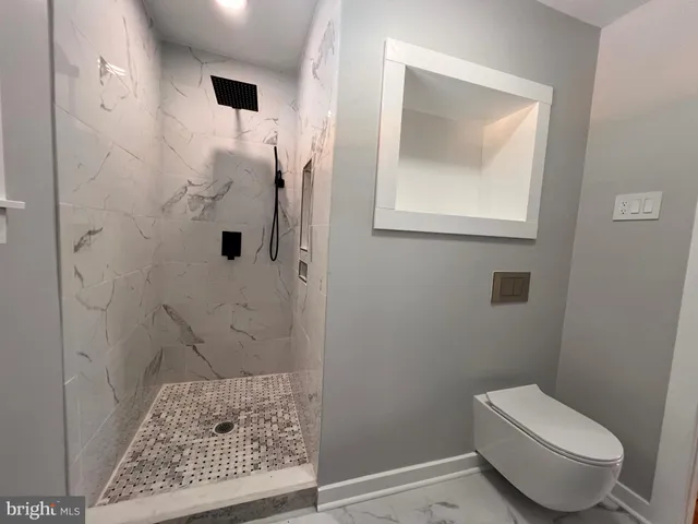 a bathroom with a toilet and a shower