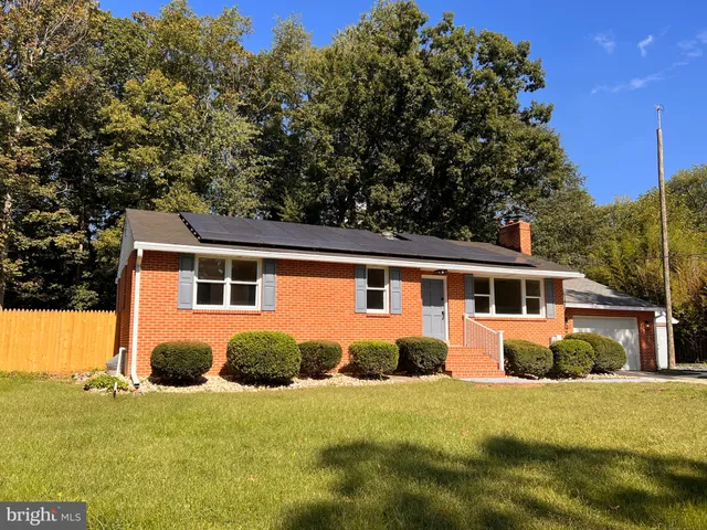 a front view of house with yard and trees around