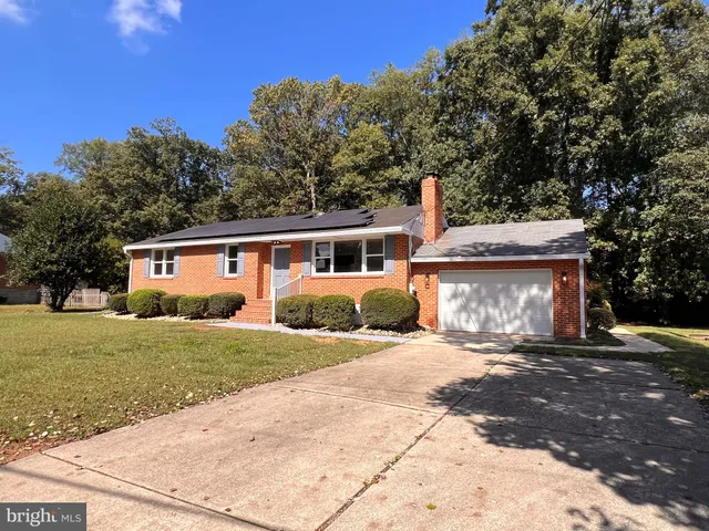a front view of a house with a yard and trees