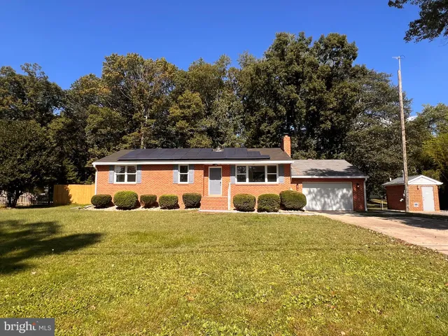 a front view of a house with a garden and yard