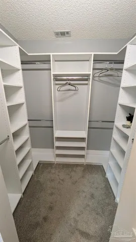 a view of walk in closet with empty racks