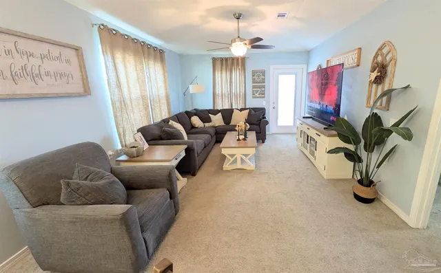 a living room with furniture a chandelier and a flat screen tv