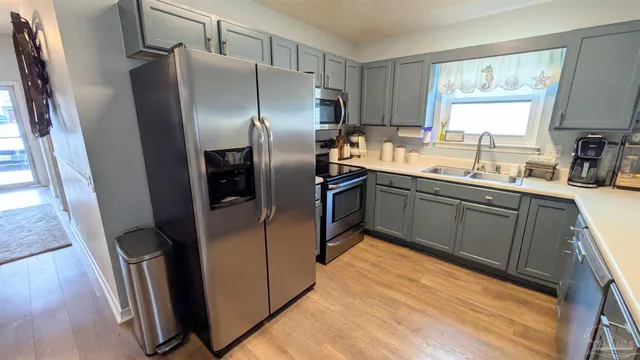 a kitchen with stainless steel appliances granite countertop a refrigerator a sink a stove and island