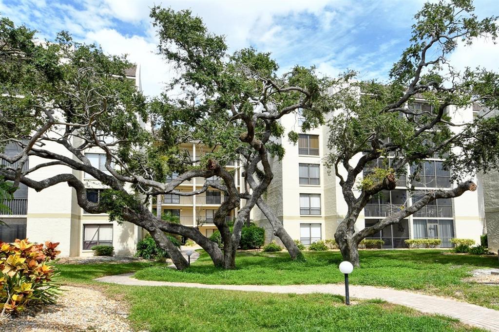 6157 Midnight Pass Road, Unit E63 Sarasota, FL 34242 - Photo 61 of 61 a front view of a building with a garden