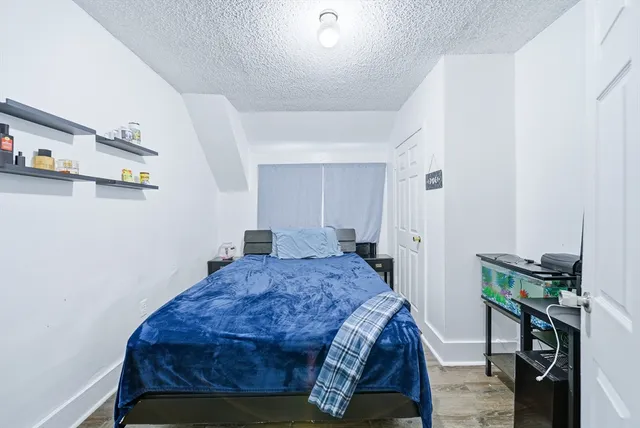 a bathroom with a granite countertop sink a toilet a mirror and shower
