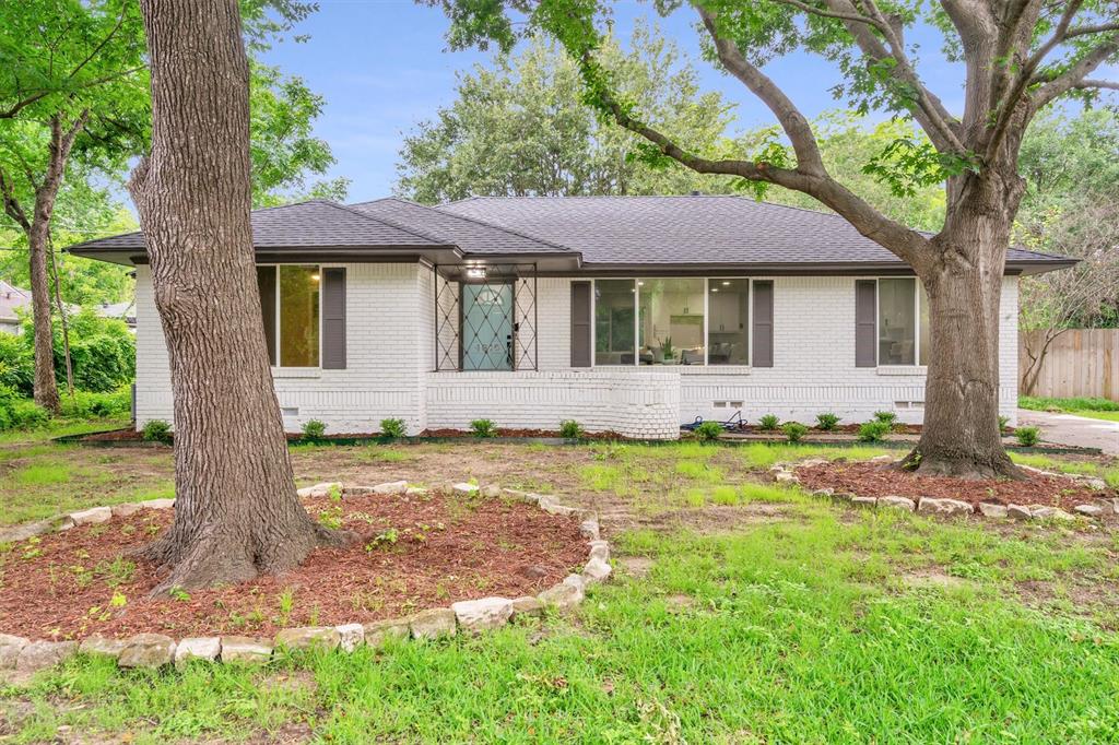 4815 Kelman Street Dallas, TX 75214 - Photo 33 of 37 White brick exterior with a dark shingle roof and contrasting dark shutters