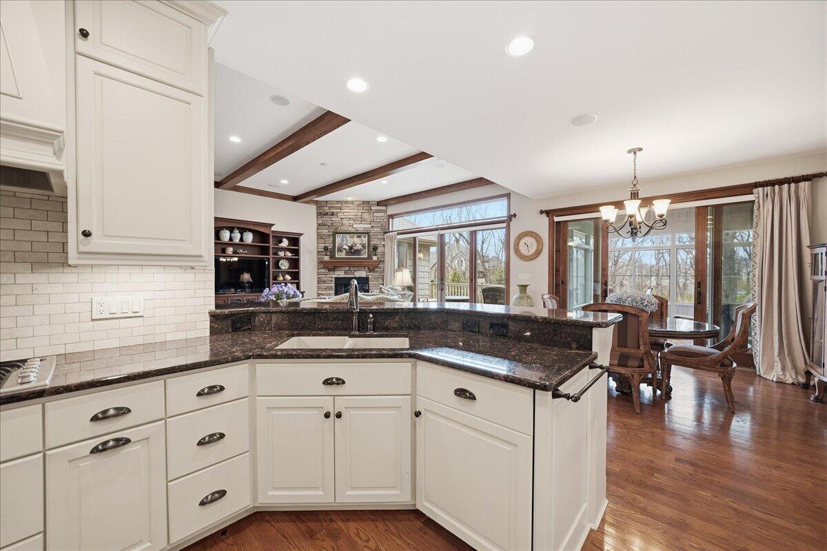 770 Quinlan Court Crown Point, IN 46307 - Photo 10 of 57 a kitchen with granite countertop a sink and white cabinets with wooden floor