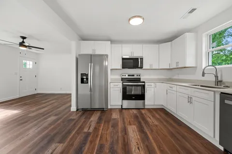 a kitchen with a refrigerator sink and cabinets