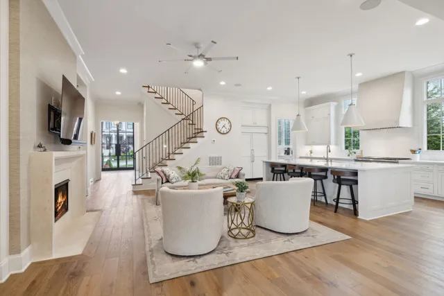a view of a white house with large windows and a table and chairs