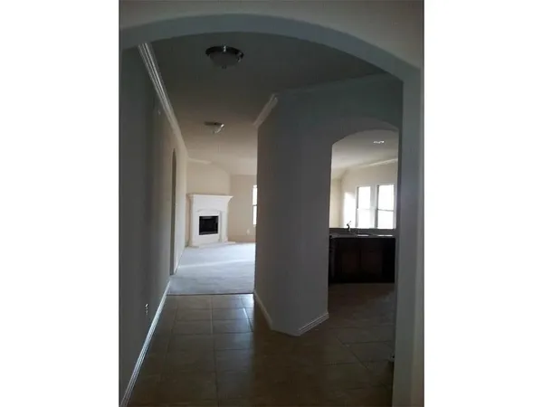 a view of a hallway with wooden floor and a living room