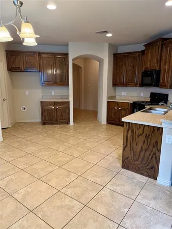 a kitchen with stainless steel appliances a sink a stove a microwave a counter top space cabinets and a window