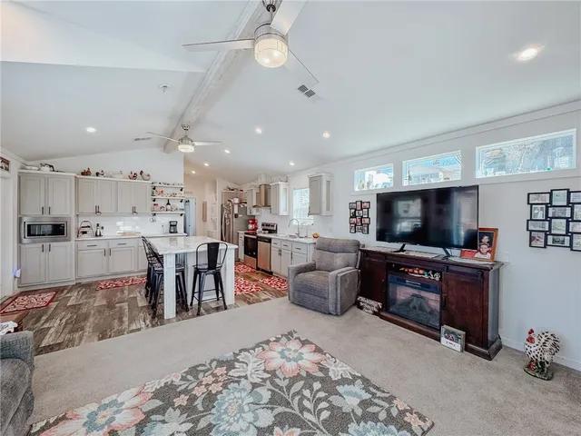 a kitchen with stainless steel appliances granite countertop a table chairs sink and cabinets
