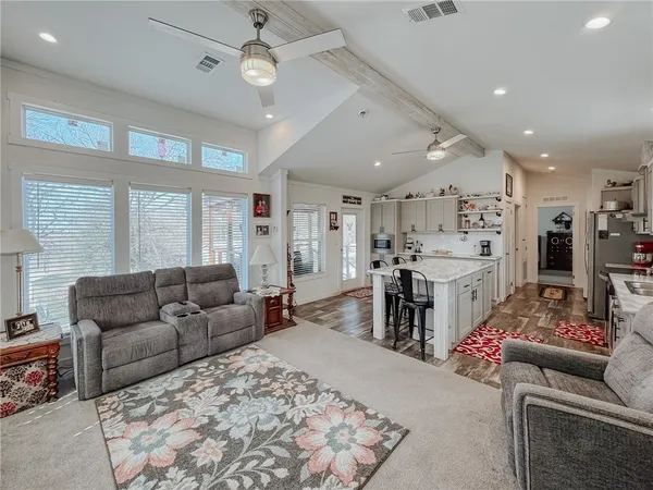 a kitchen with stainless steel appliances a sink a stove a table and chairs
