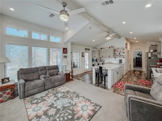 a kitchen with stainless steel appliances a sink a stove a table and chairs