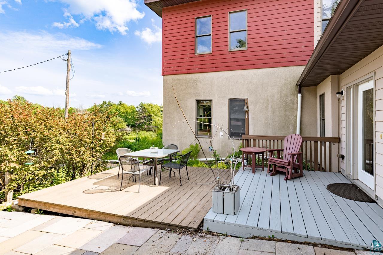 4800 Tower Road Moose Lake, MN 55767 - Photo 5 of 83 Multi-level exterior deck featuring two distinct sections: a natural wood-finish section and a light blue painted section with wood railing