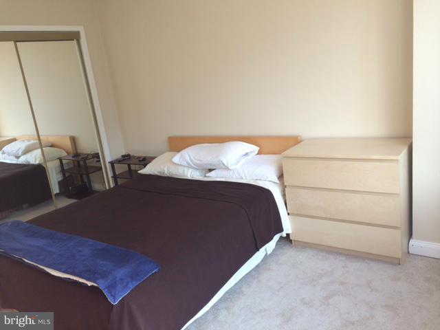 1121 Arlington Boulevard, Unit 842 Arlington, VA 22209 - Photo 13 of 30 a bedroom with a bed and a mirror
