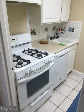 a white stove top oven sitting inside of a kitchen