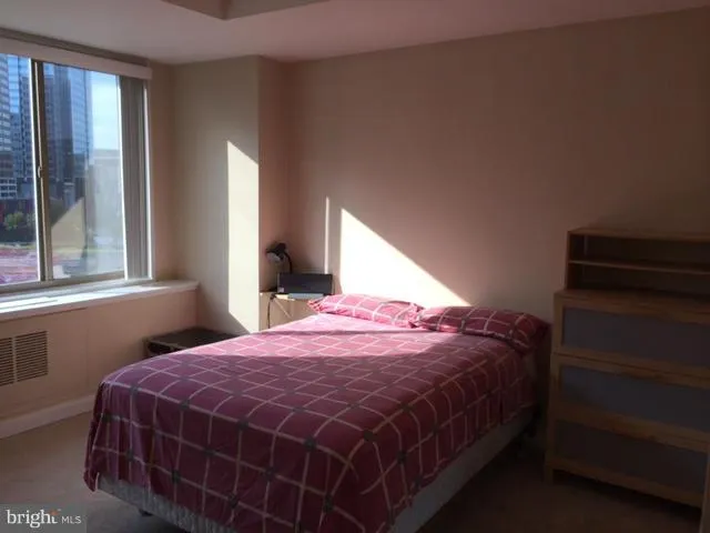 a view of an empty room with wooden floor and windows