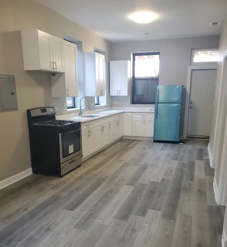 a kitchen with cabinets and wooden floor