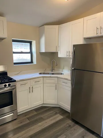 a kitchen with a refrigerator stove and white cabinets