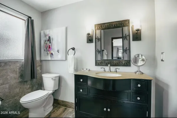a bathroom with a toilet sink and mirror