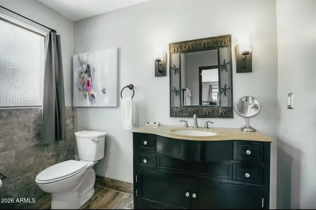 a bathroom with a toilet sink and mirror